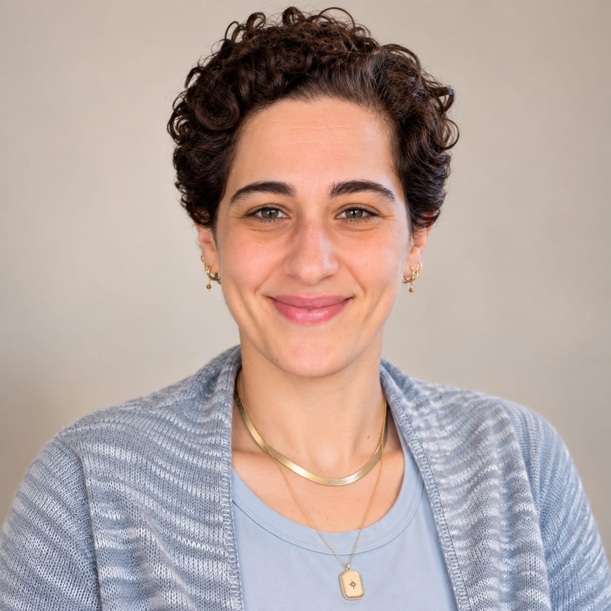 Lior Papo, Registered Psychotherapist, smiling in a light blue top and cardigan